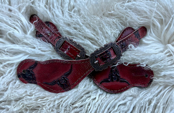 Red longhorns on dark leather