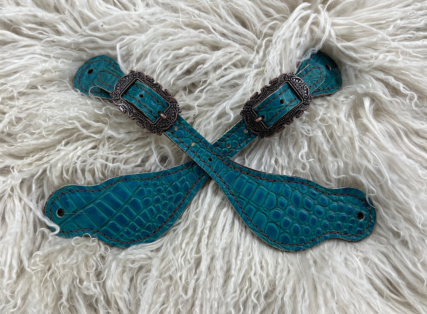 Teal gator on dark leather